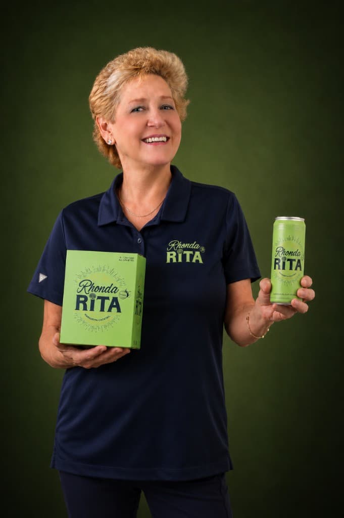 Rhonda Chapman holding RhondaRita margarita cans and four-pack